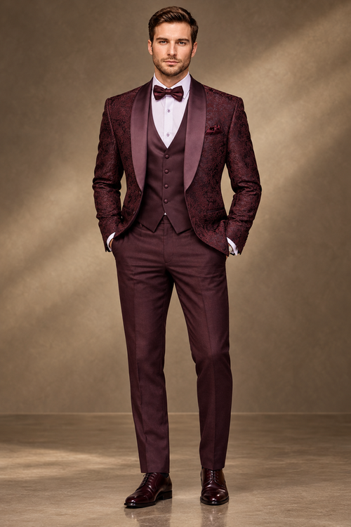 Front view of a model wearing a burgundy patterned tuxedo with shawl lapels, white shirt and matching bow tie.